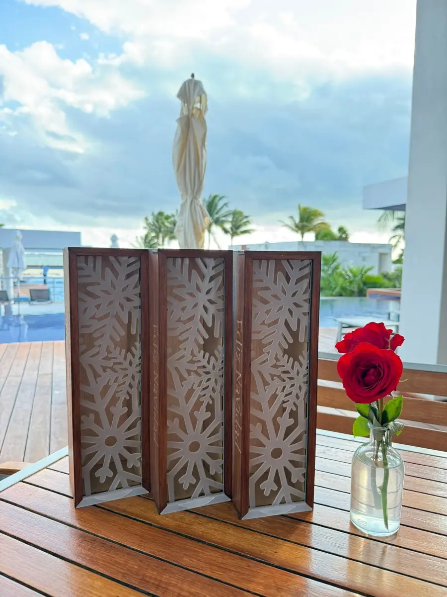 Escultura corazón de MDF cortada a láser contra cielo y palmeras